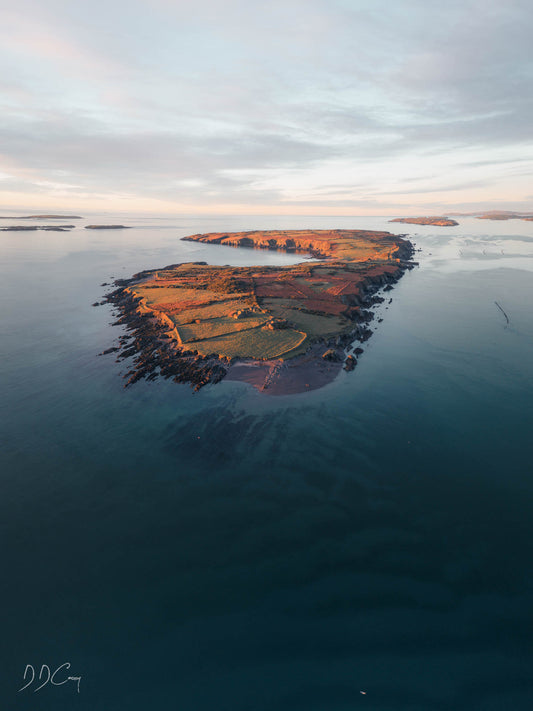 Castle island off the shores of Schull at sunrise, with a mesmerizing zebra pattern on the sea floor created by eelgrass habitat.