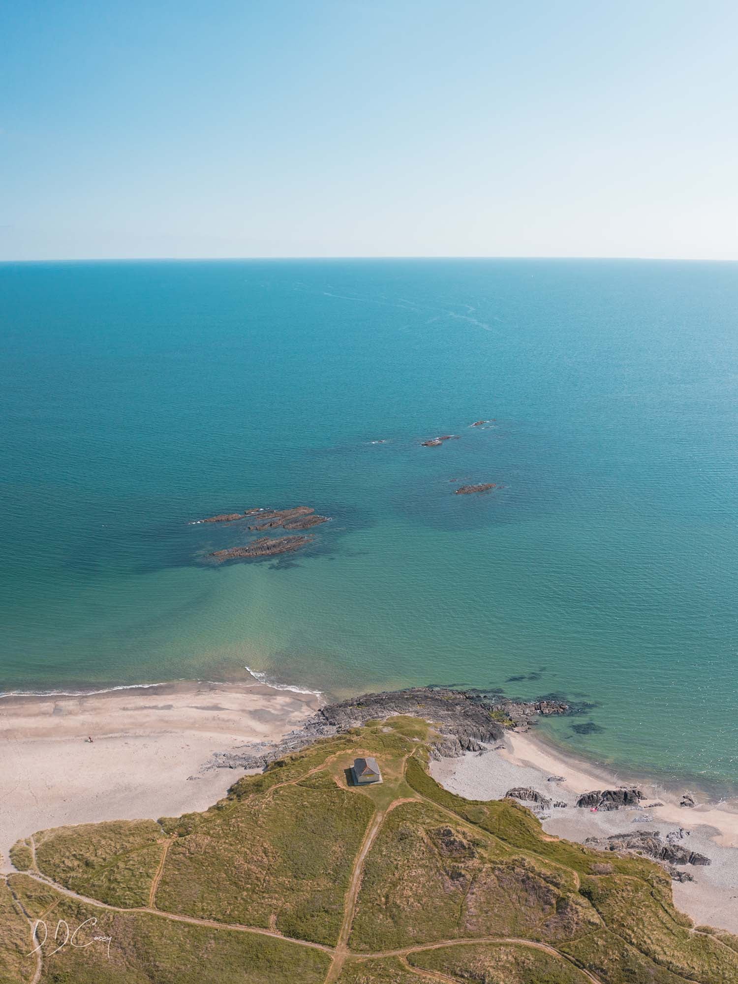 A peaceful summer day at Owenahincha strand in West Cork, showcasing the stunning landscape of the region. While the beaches can be dangerous, this photo print captures the tranquility and beauty of the area